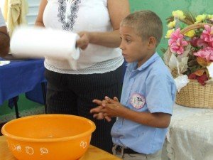 Niño estudiante en muestra de como “Lavarse las manos” 
